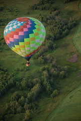 A big colorful balloon flying over the field using heat technology