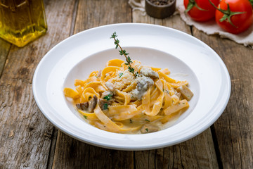 fettuccine with porcini mushrooms on wooden table