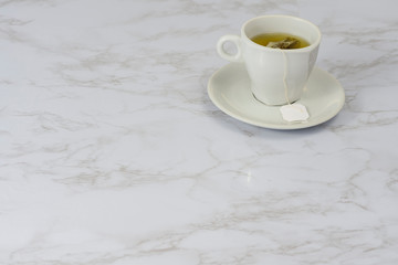 White cup with tea on a marble table. Moment of relaxation. Healthy lifestyle.