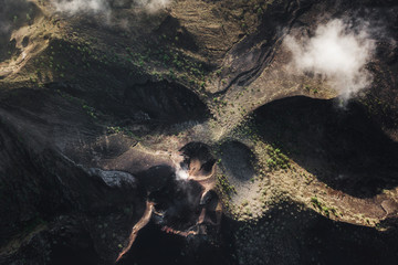 Aerial view of Batur volcano caldera in Bali. Volcanic black texture and crater rim, view from above, drone shot © Oleg Breslavtsev