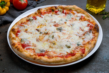 Pizza Quattro formaggi on dark concrete background
