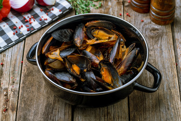 Mussels in tomato sauce on wooden table
