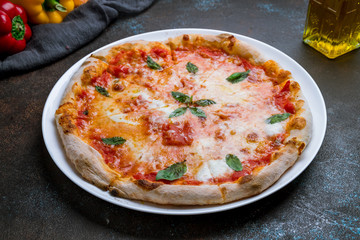 Italian pizza Margherita on dark concrete background