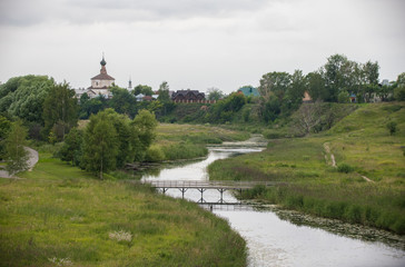 Fototapeta na wymiar A landscape of small religious village - a bridge over the stream