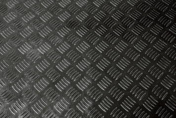 Corrugated dark and black pattern of non-slip ribbed metal or steel diamond plate rugged industrial floor textured background