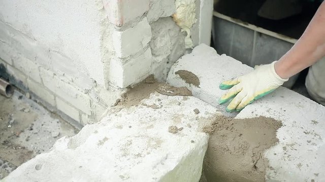 men's hands put cement mortar on the silicate blocks