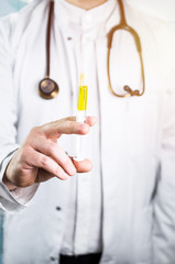 Doctor with syringe on hospital background