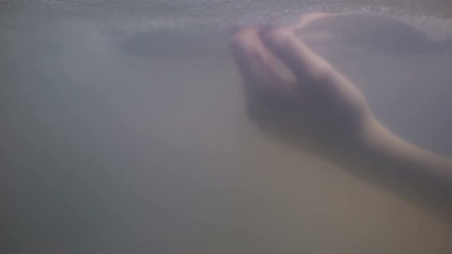 Female hand drowning under dark water, victim of murder, crime scene, close-up