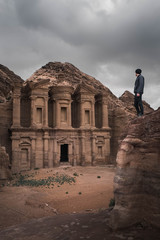 a person standing on the rock watching an old temple