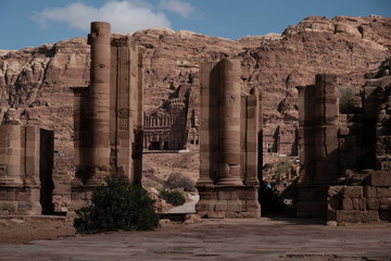 a person walking through ruins of ancient temple in Petra Jordan