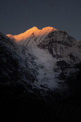 mountain at sunrise. Mountain with a glacier tongue at sunrise. Sun rays at the peak of the mountain