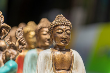 Buddha statue figures souvenir on display for sale on street market in Bali, Indonesia. Handicrafts and souvenir shop display, close up