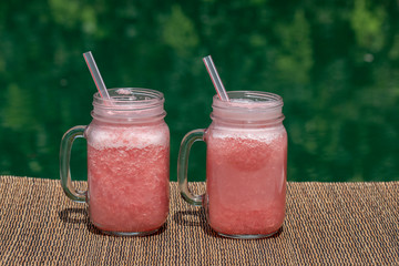 Grapefruit pink shake or smoothie on the table, close up. Breakfast in island Bali, Indonesia