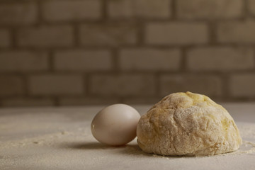 Fresh dough on table on brick wall background