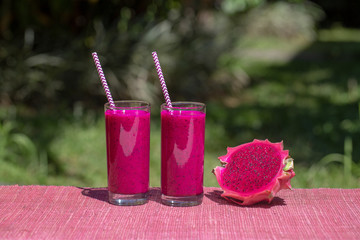 Fresh smoothies from a dragon fruit, banana, mango and papaya in glass. Island Bali, Indonesia. Close up