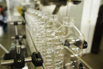 Line for the production of plastic PET bottles on the background of the worker. Preparation of containers for drinks and sunflower oil