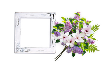 Floral bouquet with lilacs, magnolia flowers and empty picture frame in shabby chic style isolated on white background. Copy space for photo or text.