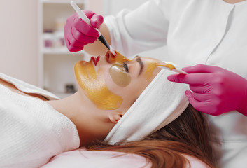 Spa Woman applying Facial cleansing Mask.