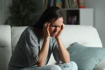 Woman at home suffering migraine in the night