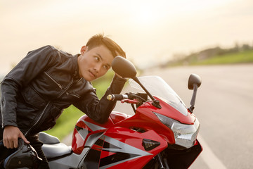 Handsome motorcyclist looking mirror to check his face on the road