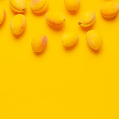 Ripe fresh apricots fruits on yellow background. Flat lay, top view, copy space. Fresh organic apricots, diet vegan food. Creative Apricot pattern. Harvest concept