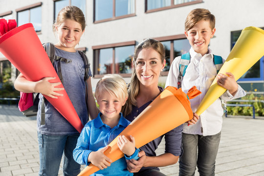 Woman and kids at enrolment day with school cones