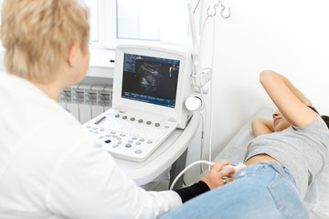 Fototapeta na wymiar The doctor is preparing to conduct ultrasound research. smears the gel ultrasonic sensor