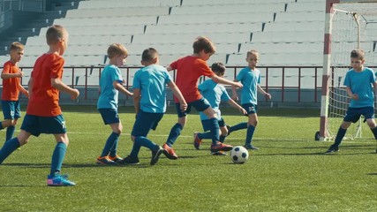 Kids playing soccer on big stadium, dribbling and attacking goal post - Powered by Adobe