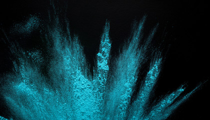 Freeze motion of blue powder throwing on black background