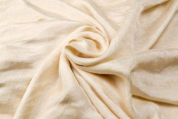 Soft smooth beige silk fabric background. Fabric texture.