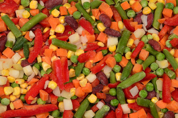 Sliced vegetables, corn, beans, peas, carrots, sweet peppers background.