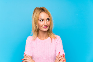 Young blonde woman over blue background thinking an idea