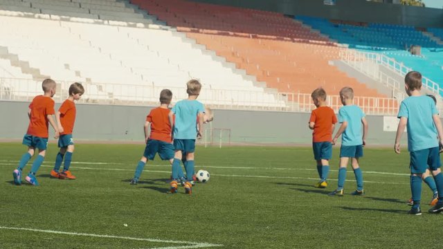 Boys training soccer on big arena, fighting for ball