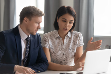 Asian manager mentor consult caucasian client teaching intern with laptop