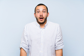 Fototapeta premium Colombian man over isolated blue wall with surprise facial expression