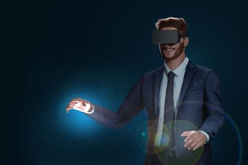 Virtuelles Erlebnis mit VR-Brille. Erfolgreicher Mann im Anzug ist trägt eine Virtuell Reality Brille. Versucht mit seinen Händen die virtuelle Welt zu berühren.