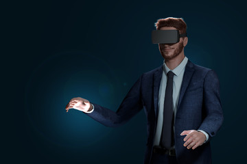 Virtuelles Erlebnis mit VR-Brille. Erfolgreicher Mann im Anzug ist trägt eine Virtuell Reality Brille. Versucht mit seinen Händen die virtuelle Welt zu berühren.