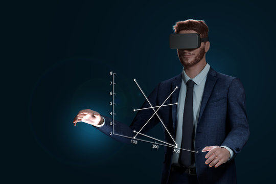 Virtuelles Erlebnis mit VR-Brille. Erfolgreicher Mann im Anzug ist tr&auml;gt eine Virtuell Reality Brille. Versucht mit seinen H&auml;nden die virtuelle Welt zu ber&uuml;hren.