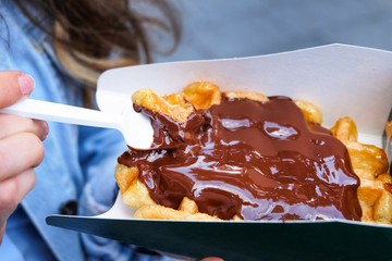 Woman eating hot belgian waffles with chocolate