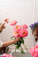 Hands of a young florist woman making modern bouquet of flowers
