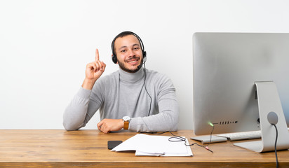 Telemarketer Colombian man showing and lifting a finger in sign of the best