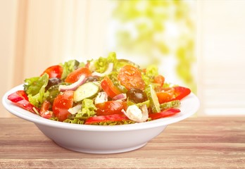 Close-up photo of fresh salad with vegetables in white plate