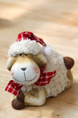 The smile teddy sheep on the wooden table.