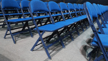 Many blue chairs stand in a row before the event