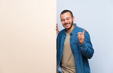 Colombian man holding an empty placard laughing