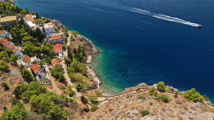Obraz premium Aerial drone photo of small rocky beach of Avlaki with clear turquoise sea near picturesque main village in island of Ydra or Hydra, Saronic gulf, Greece