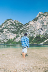 man walking by lake beach mountains on background