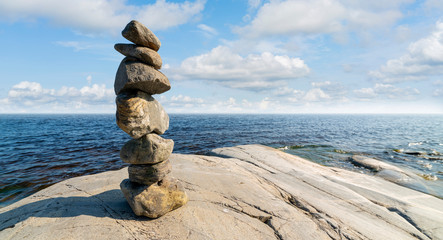 Stacked Rocks balancing, stacking with precision. Stone tower on shore. Copy space.