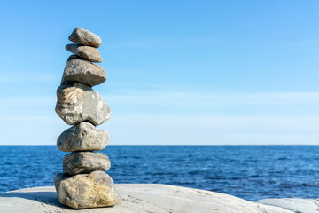 Stacked Rocks balancing, stacking with precision. Stone tower on the shore. Copy space.