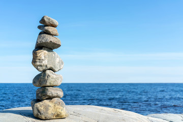 Fototapeta na wymiar Stacked Rocks balancing, stacking with precision. Stone tower on the shore. Copy space.